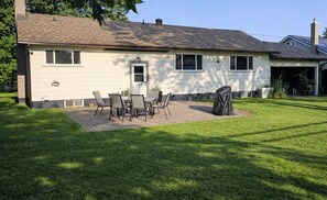 A two-story house with a patio area featuring a table and chairs. - Modern 3BR Upstairs Suite | Private Entrance | Sault Ste. Marie (Sault Ste. Marie)