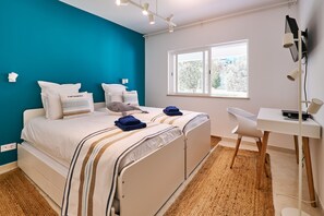Ein Schlafzimmer mit einem Bett, einem Schreibtisch und einem Fenster.