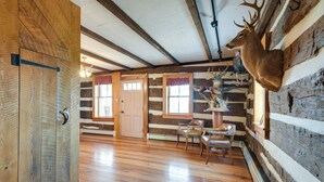 A log cabin interior with wooden floors, a deer head mounted on the wall, and a rustic dining area. - Rustic Wellsville Home - 5 Mi to Roundtop Mountain (Wellsville)