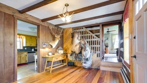 A room with wooden floors, a desk with a lamp, and mounted animal heads on the wall. - Rustic Wellsville Home - 5 Mi to Roundtop Mountain (Wellsville)