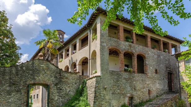 A historic building with a stone facade, multiple balconies, and a central courtyard.