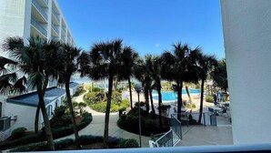 A hotel with a pool area, palm trees, and a clear blue sky. - Lagoon Front w/Boat Launch & Parking~2BR/1B (Gulf Shores)