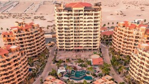 Een resort met meerdere gebouwen, een centraal gelegen zwembad en omliggend groen.