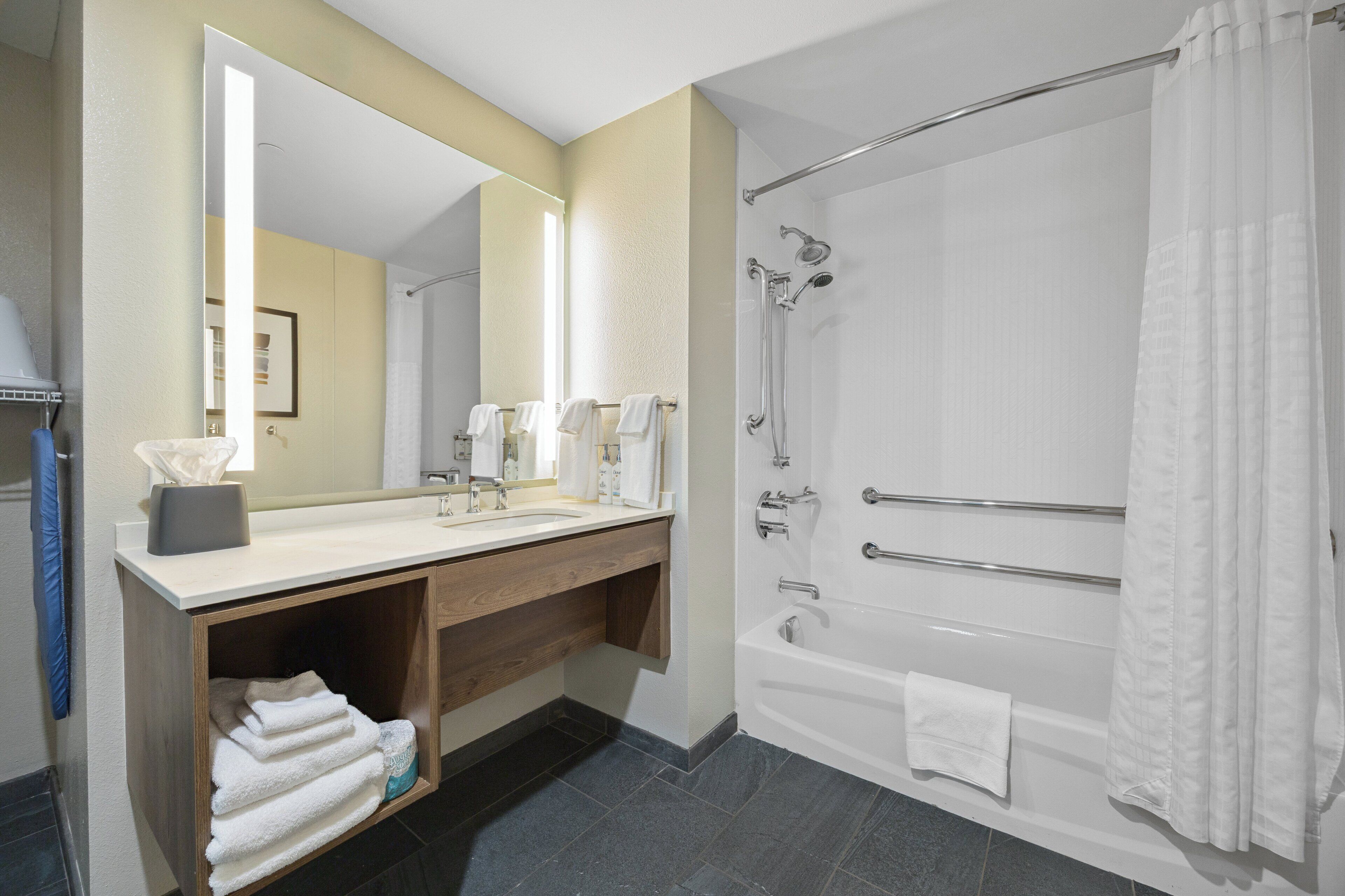Ein modernes Badezimmer mit Waschbecken, Spiegel und Dusche.