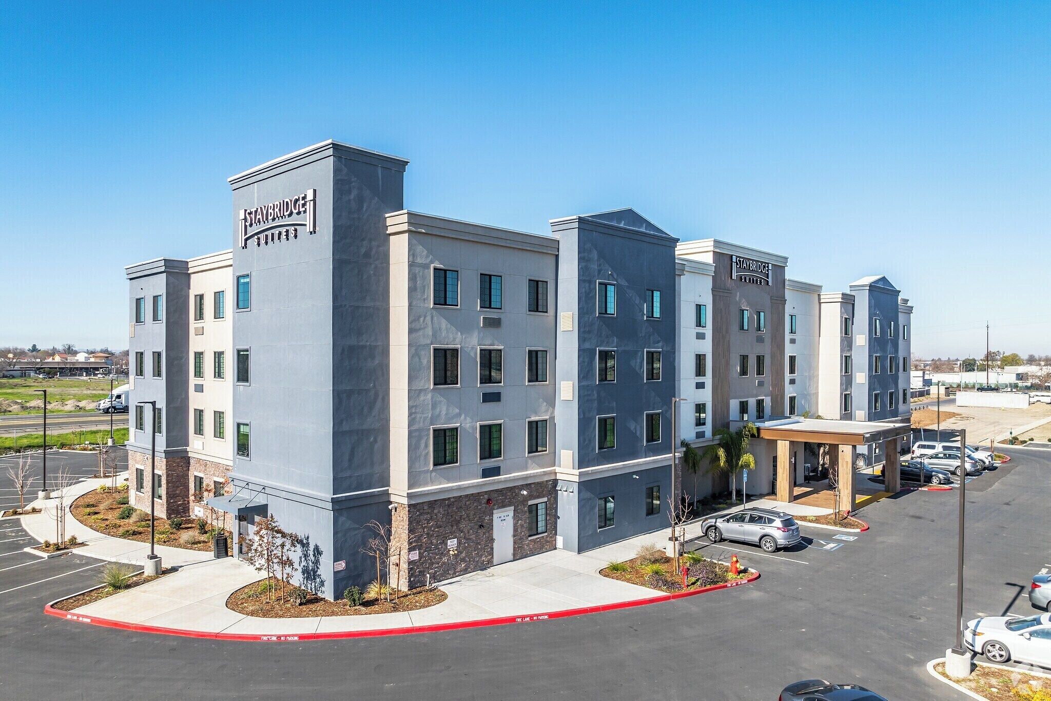 A multi-story hotel with a modern design, featuring a prominent Staybridge Suites sign.