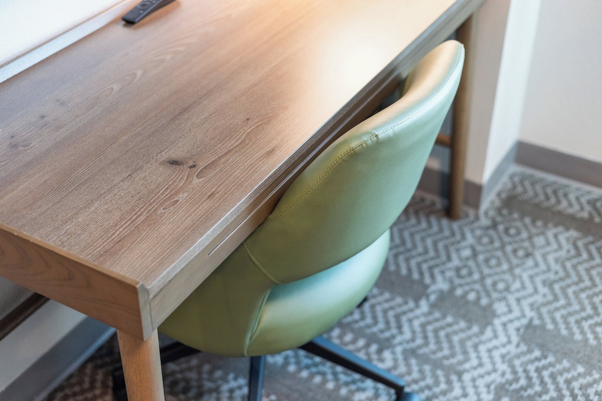 Una mesa de madera con una silla verde.
