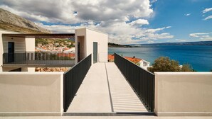 Een modern gebouw met een balkon met uitzicht op een wateroppervlak en een verafgelegen landschap.