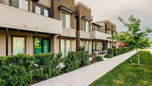A row of modern townhouses with a uniform architectural style, featuring large windows and a well-maintained lawn. - Loaded Logan Loft near USU & EVERYTHING Else - Sleeps 8 in beds (North Logan)
