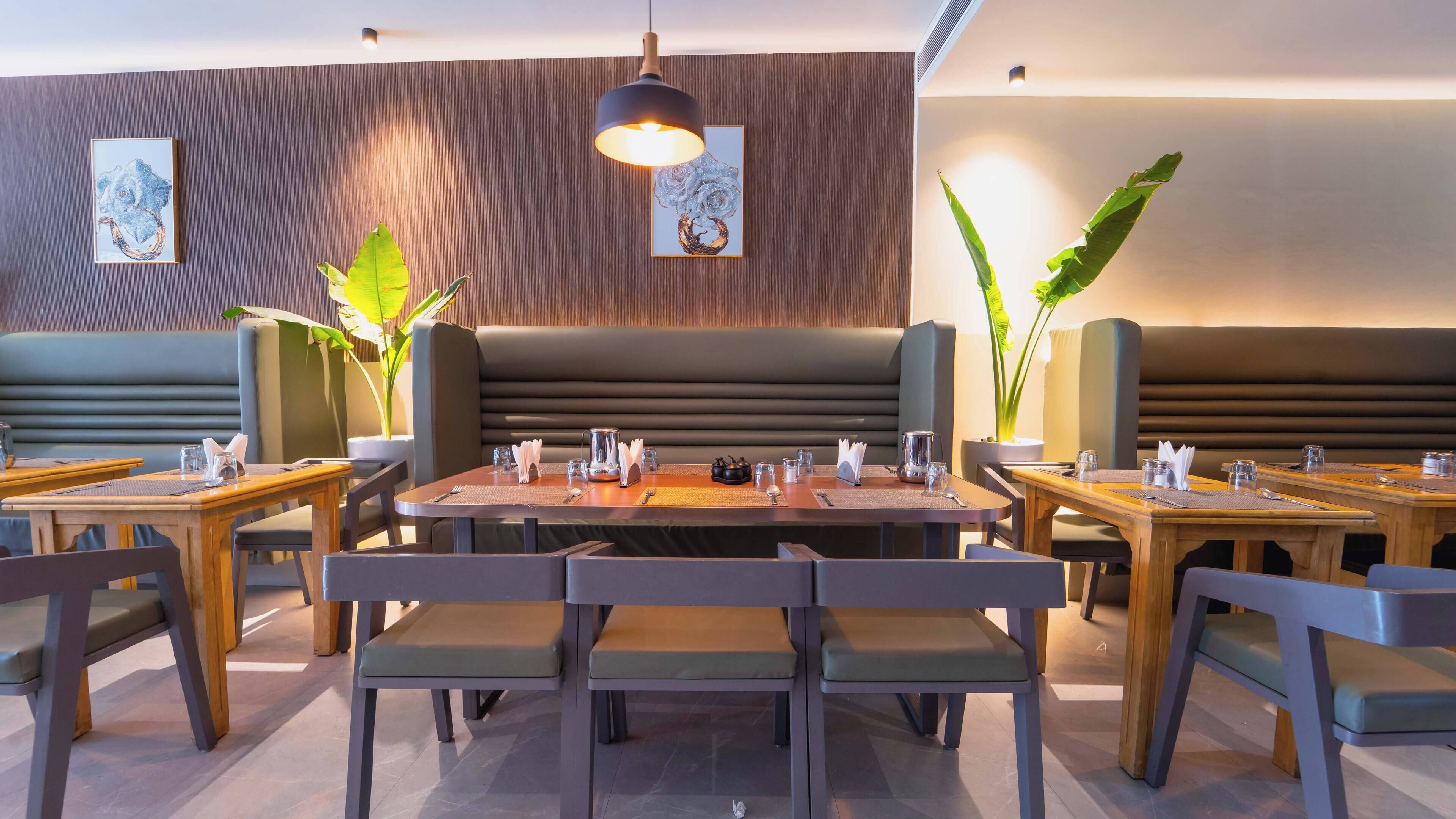 A restaurant with booths and tables, some with plants.