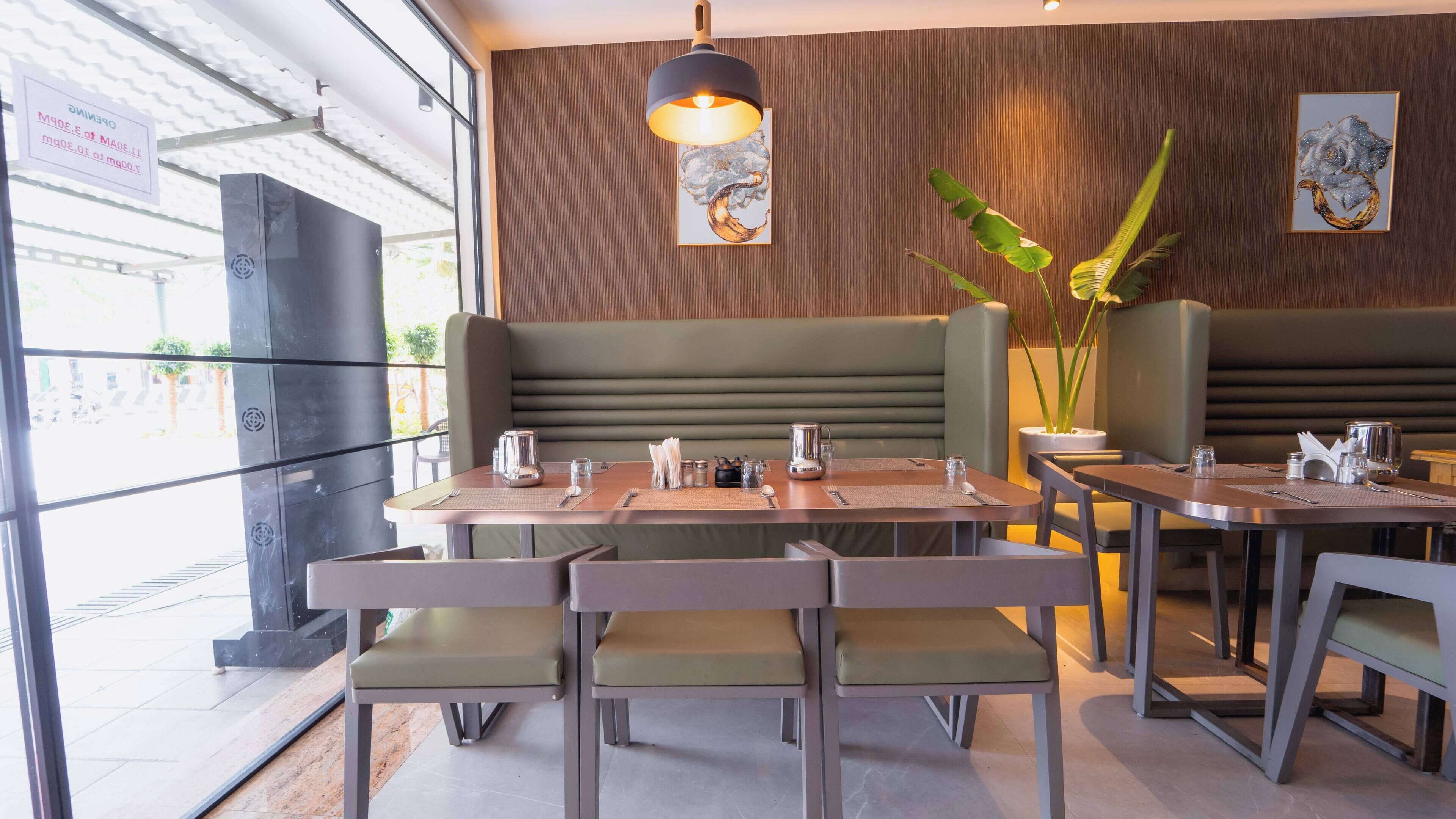 A restaurant interior with booth seating, a wooden wall, and a framed artwork.