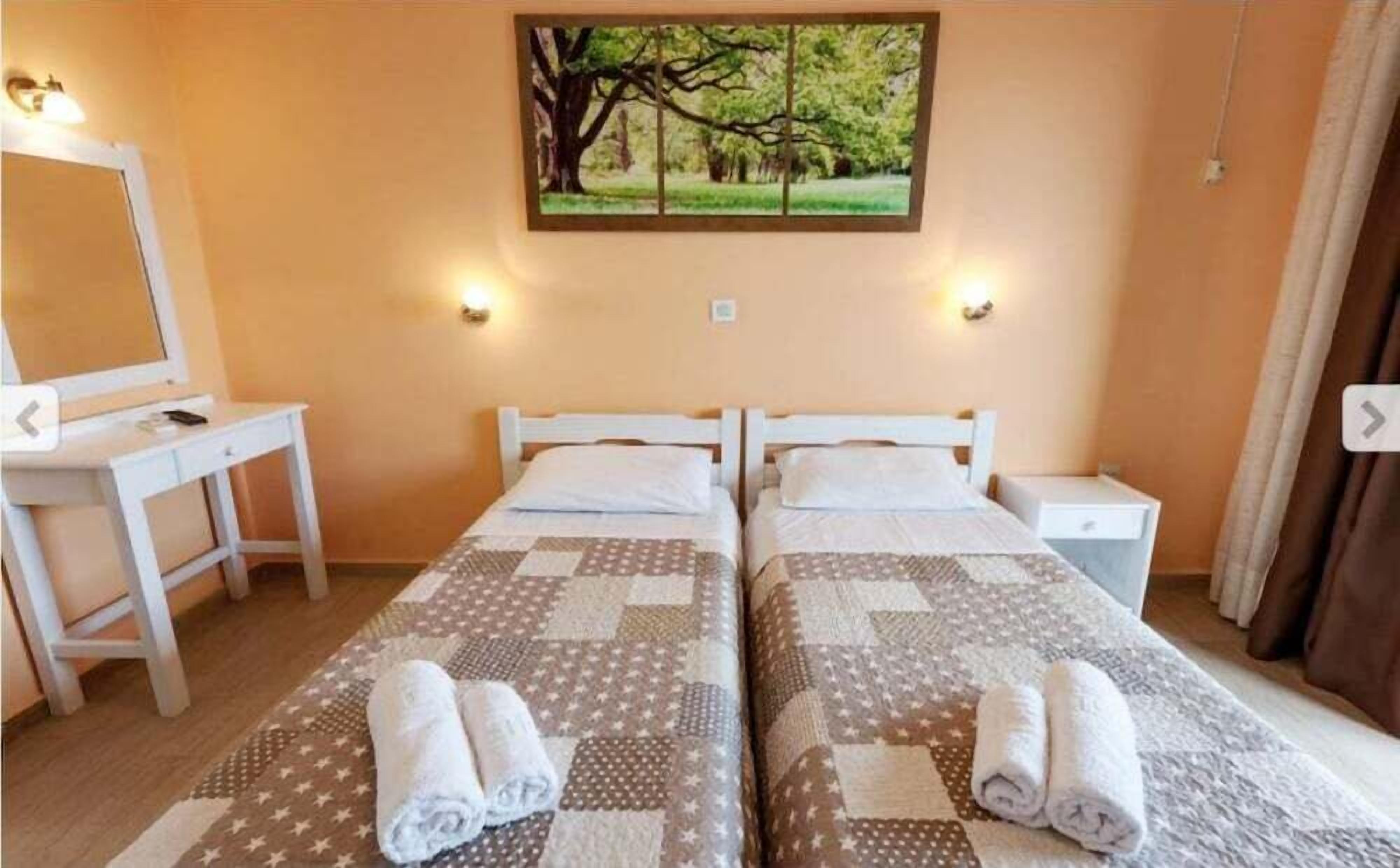 Une chambre double avec deux lits, un bureau et une table de chevet.