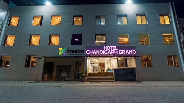 Un hôtel avec une enseigne indiquant « Hôtel Chandigarh Grand » et un logo pour « Treebo Chandigarh Grand ».