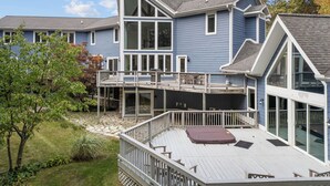 Une maison à deux étages dotée d’une grande terrasse, d’un patio couvert et d’une piscine.