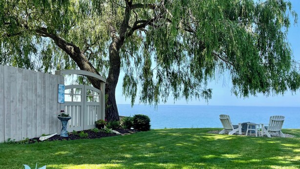 Un jardin bien entretenu avec une terrasse, un espace salon et une vue sur la mer.