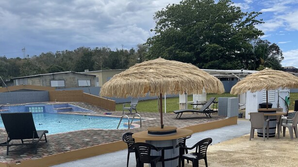 A pool area with lounge chairs, a barbecue setup, and thatched umbrellas. - Villa Destiny Family Friendly Destination with private pool & jacuzzi &more. (Cacao)