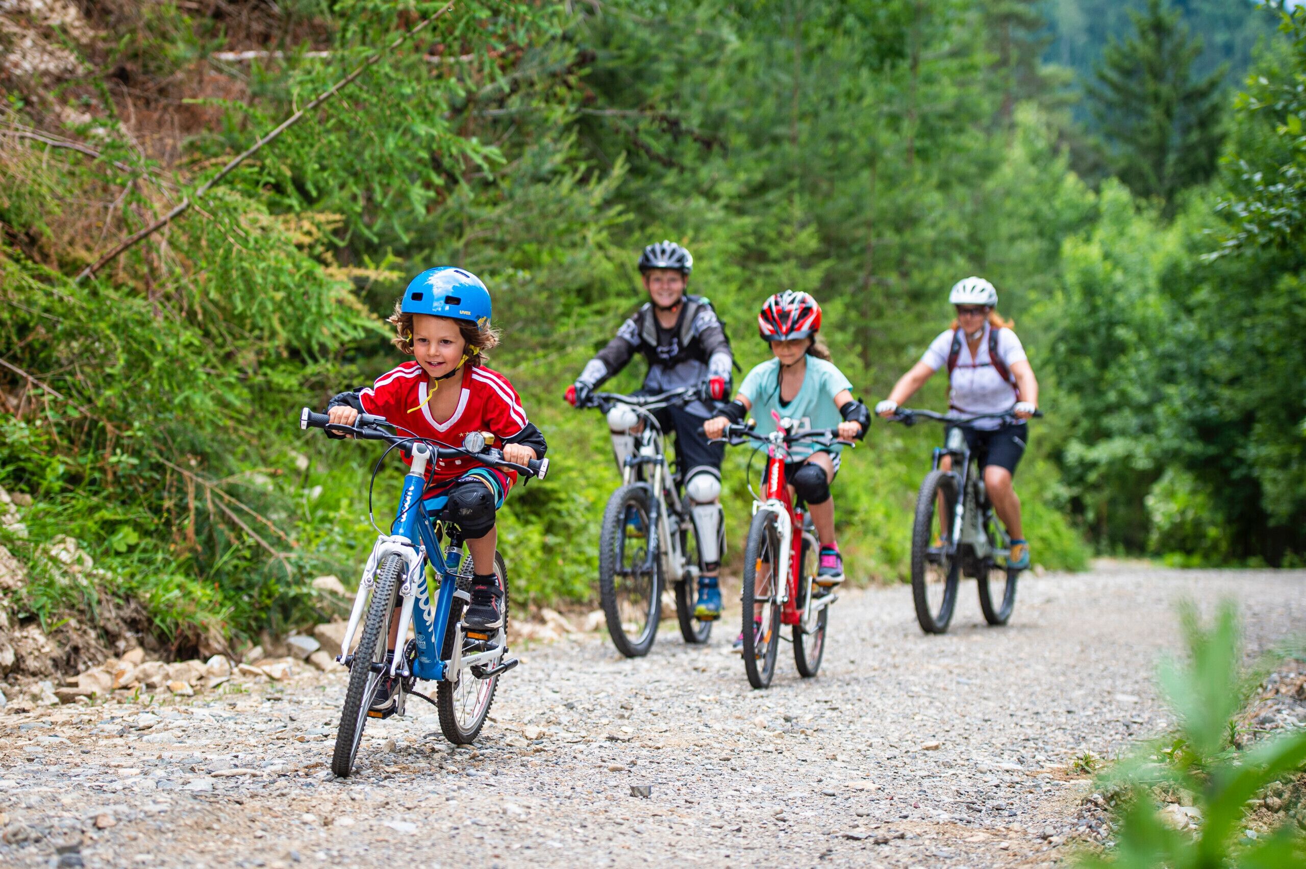 A group of cyclists on a gravel path surrounded by greenery.