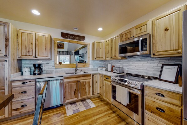 Kitchen features light cabinetry, stainless steel appliances, and a subway tile backsplash, including a dishwasher, double oven, and microwave.