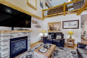 Cozy living room with a fireplace, comfortable sofa, and television.