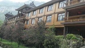 Ein mehrstöckiges Gebäude mit traditioneller Architektur, Balkonen und einer Bergkulisse.