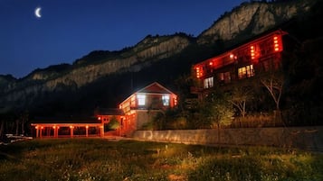 Un bâtiment à plusieurs étages, doté d’un balcon et offrant une vue sur un paysage montagneux.