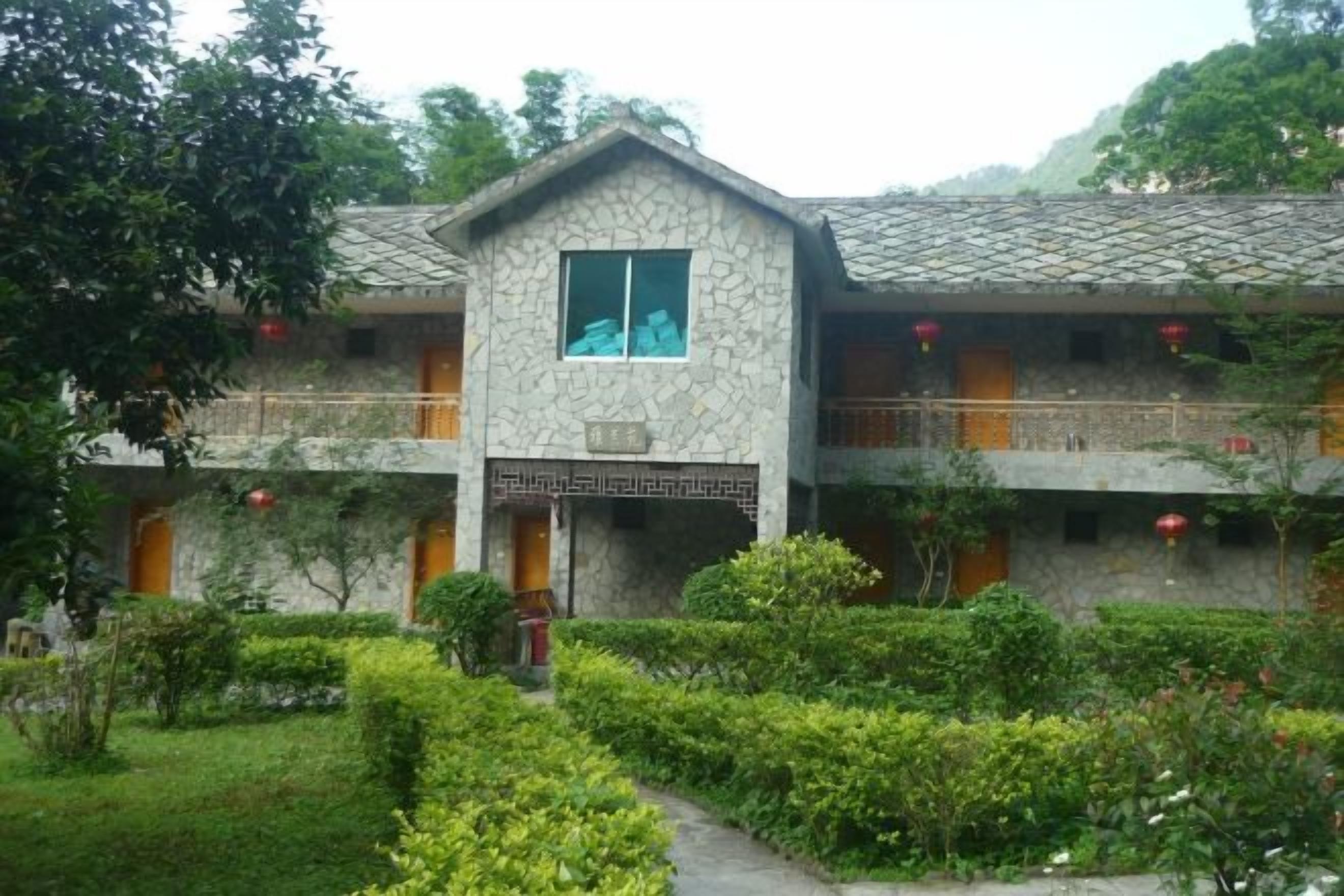 A traditional building with a stone facade, multiple balconies, and a well-maintained garden.