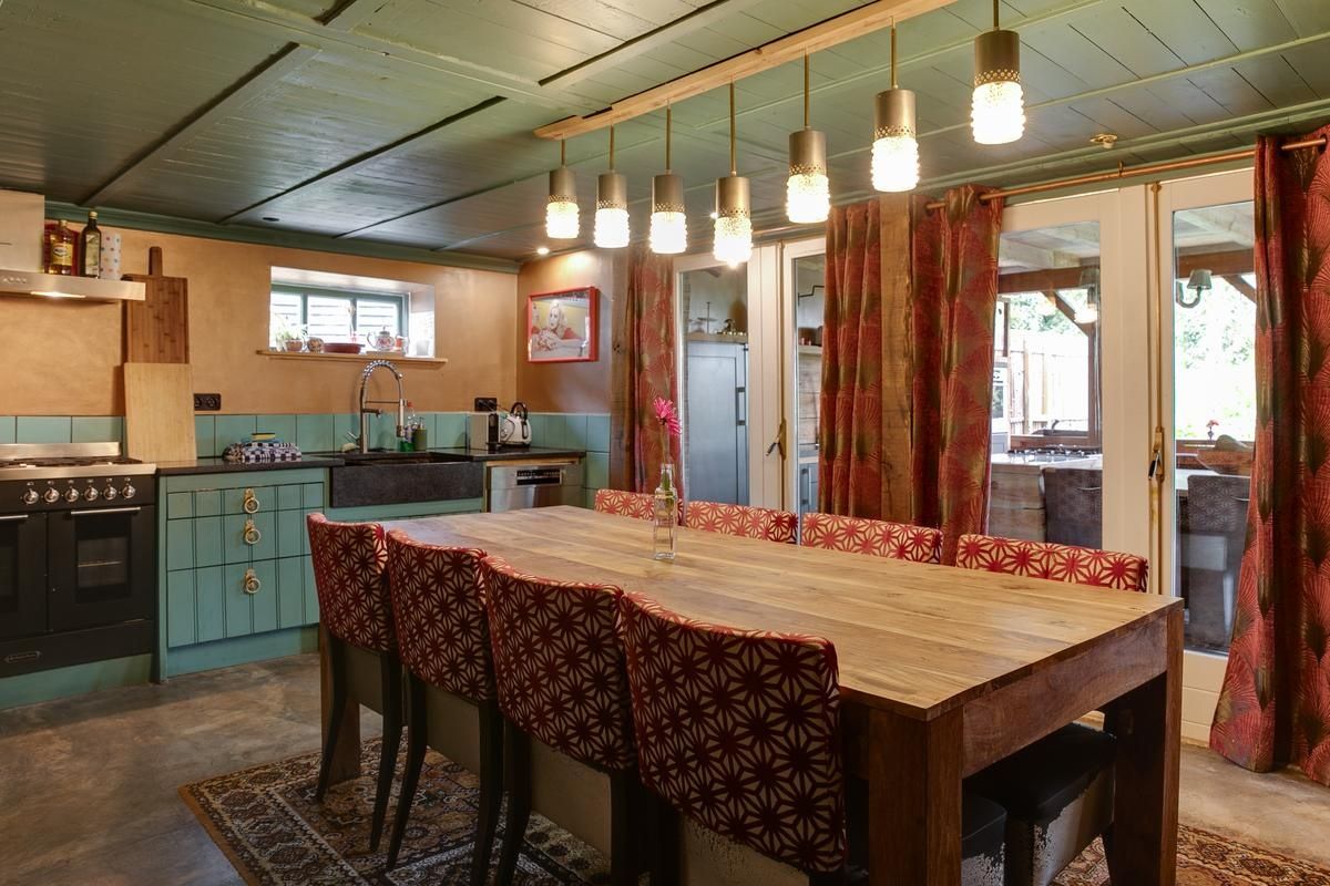 Une cuisine dotée d’un îlot central, de luminaires suspendus et offrant une vue sur l’extérieur.