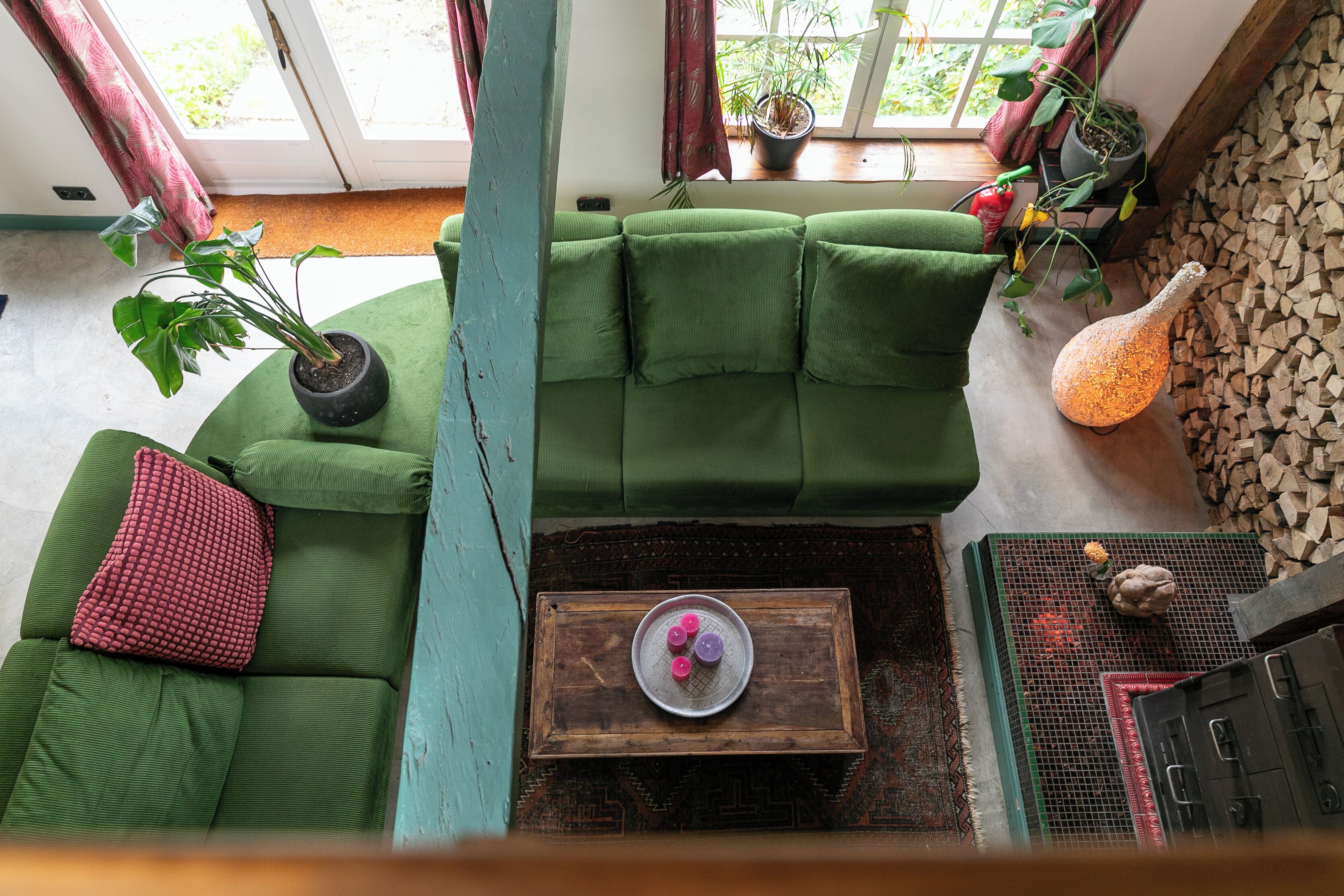 A green sofa, a wooden coffee table, a potted plant, and a decorative vase.