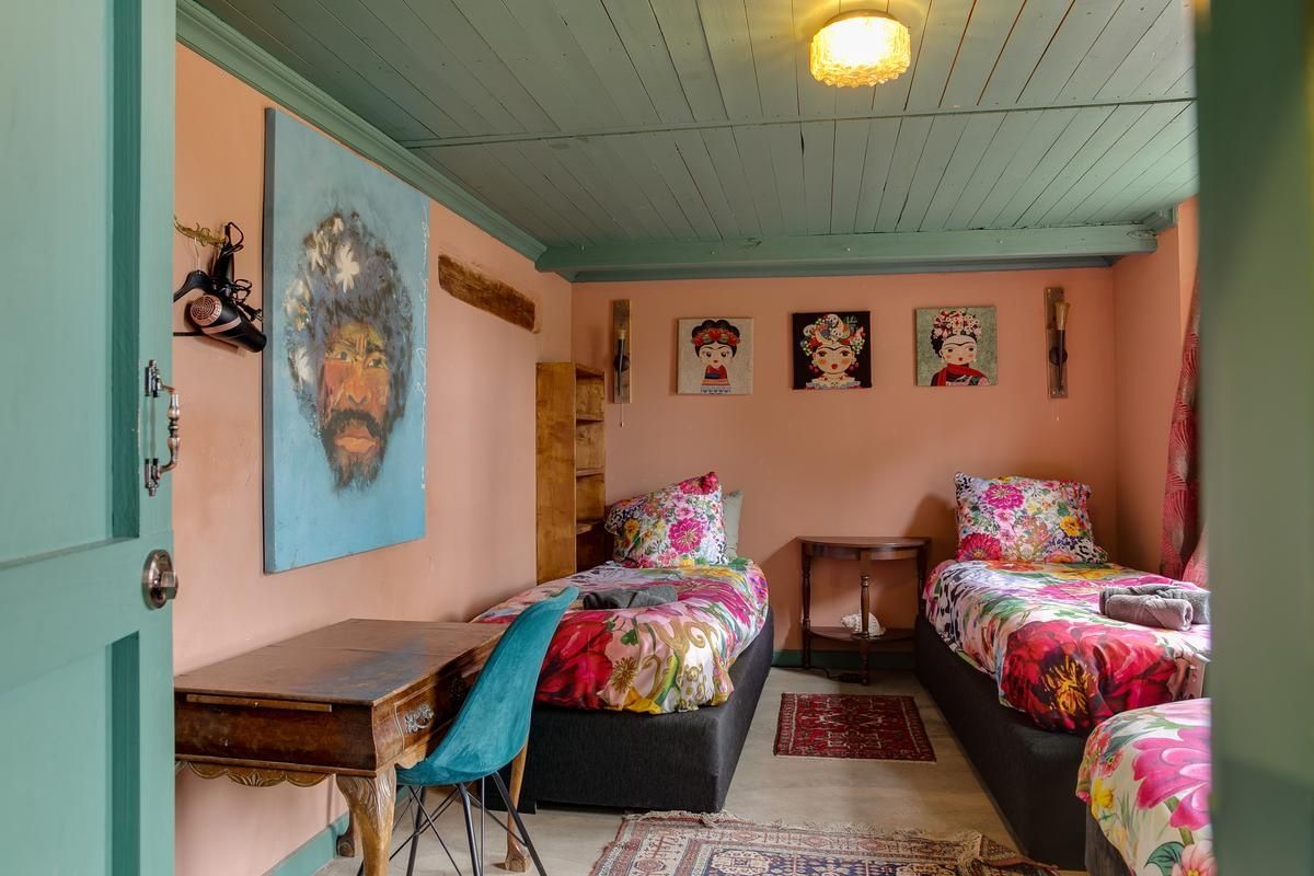 A room with two beds, a desk, and a chair.