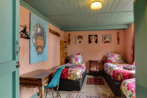 A room with two beds, a desk, and a chair.
