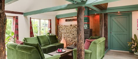 Una sala de estar acogedora con muebles verdes, una chimenea y una puerta con la leyenda 'REATOR'.