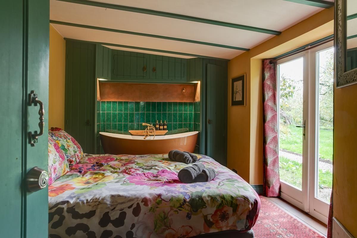 Quarto com cama, banheira e vista para o exterior.