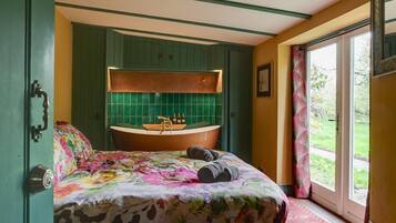 Quarto com cama, banheira e vista para o exterior.