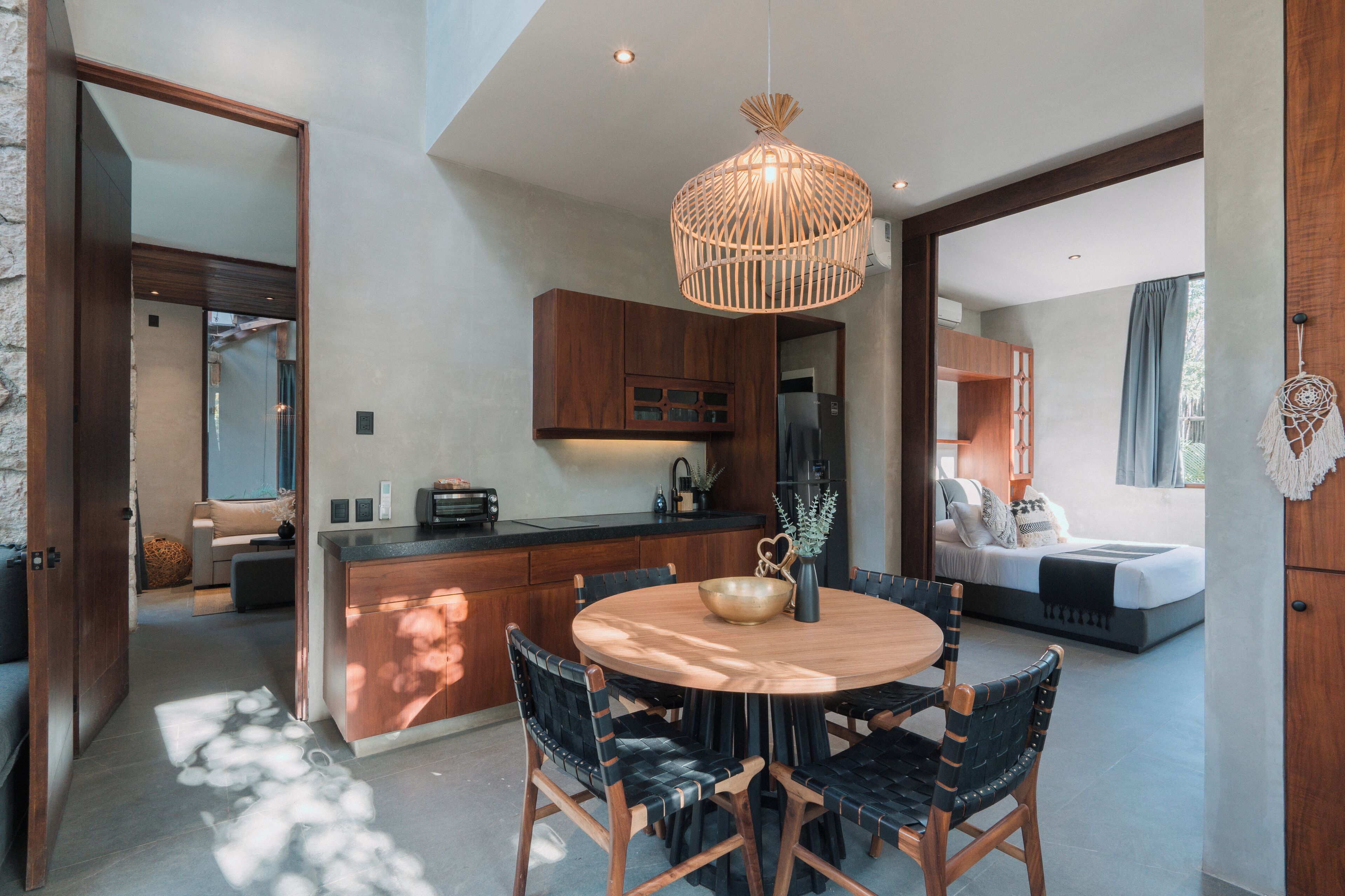 Una cocina moderna con armarios de madera, una mesa de comedor redonda y una lámpara colgante.