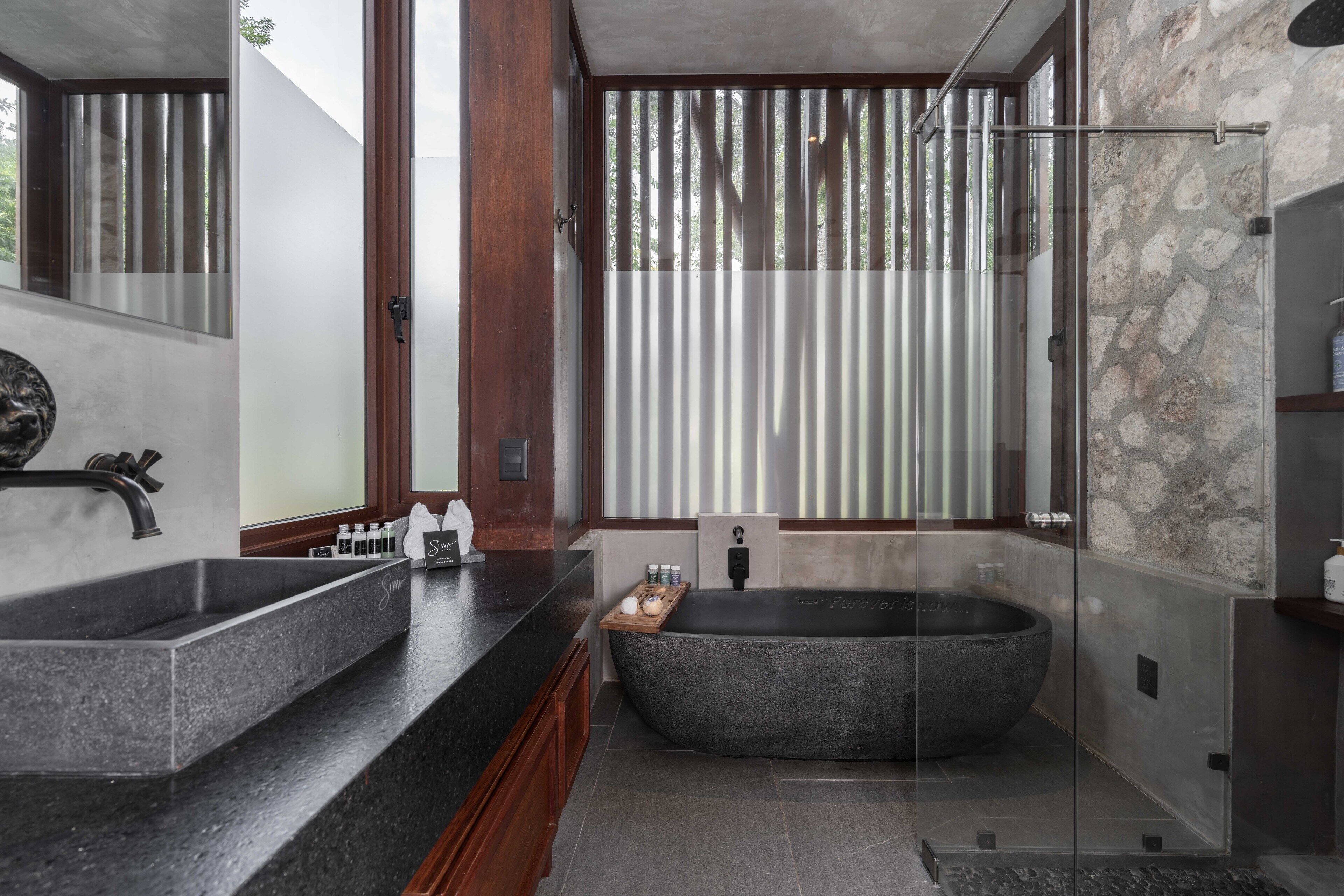 A modern bathroom with a large freestanding bathtub, a double sink vanity, and a glass-enclosed shower area.