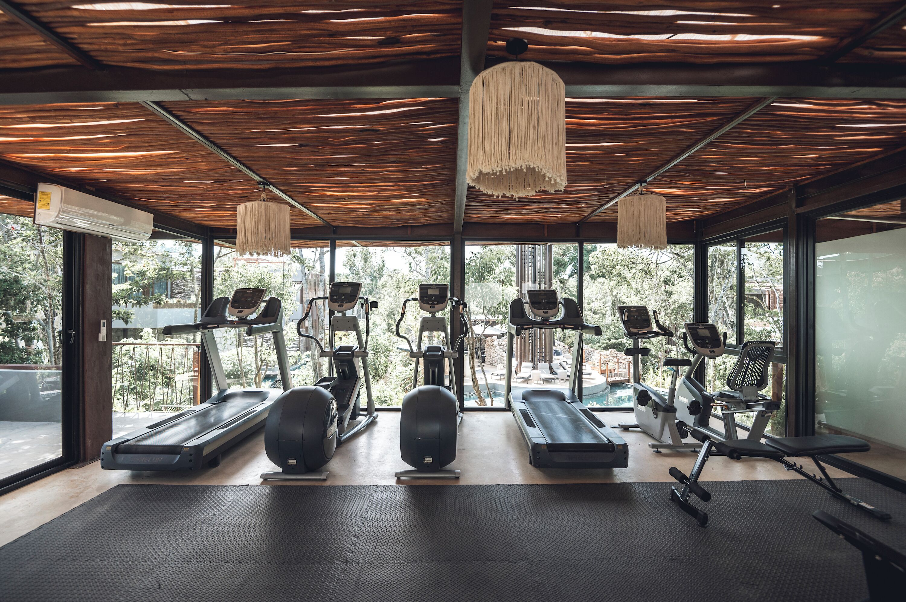 A gym with treadmills, elliptical machines, and a rowing machine.