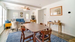 A dining area with a wooden table, four chairs, a blue rug, and a ceiling fan. - Charleston Home w/ Porch - 3 Mi to Folly Beach! (Charleston)