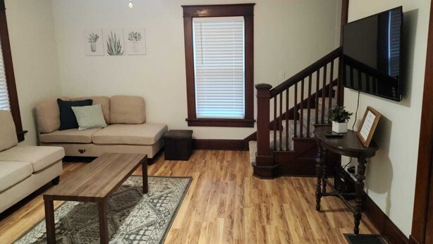 A living room with a sofa, coffee table, and a staircase. - Family Home in Carthage (Carthage)