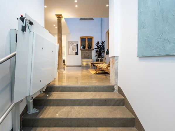 Una escalera conduce a una habitación con cocina, una mesa de comedor y sillas.