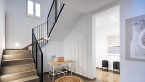Un intérieur moderne avec un escalier, un bureau avec un ordinateur portable et un tapis rond.