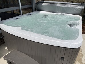 A hot tub with a wooden exterior and a white interior. - Private, newly renovated lakefront cottage on 10+ acres of land. (Brooklyn)