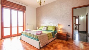 A bedroom with a large bed, a nightstand, a lamp, and a chandelier. - 4 bedroom stunning home in Roccadaspide (Roccadaspide)