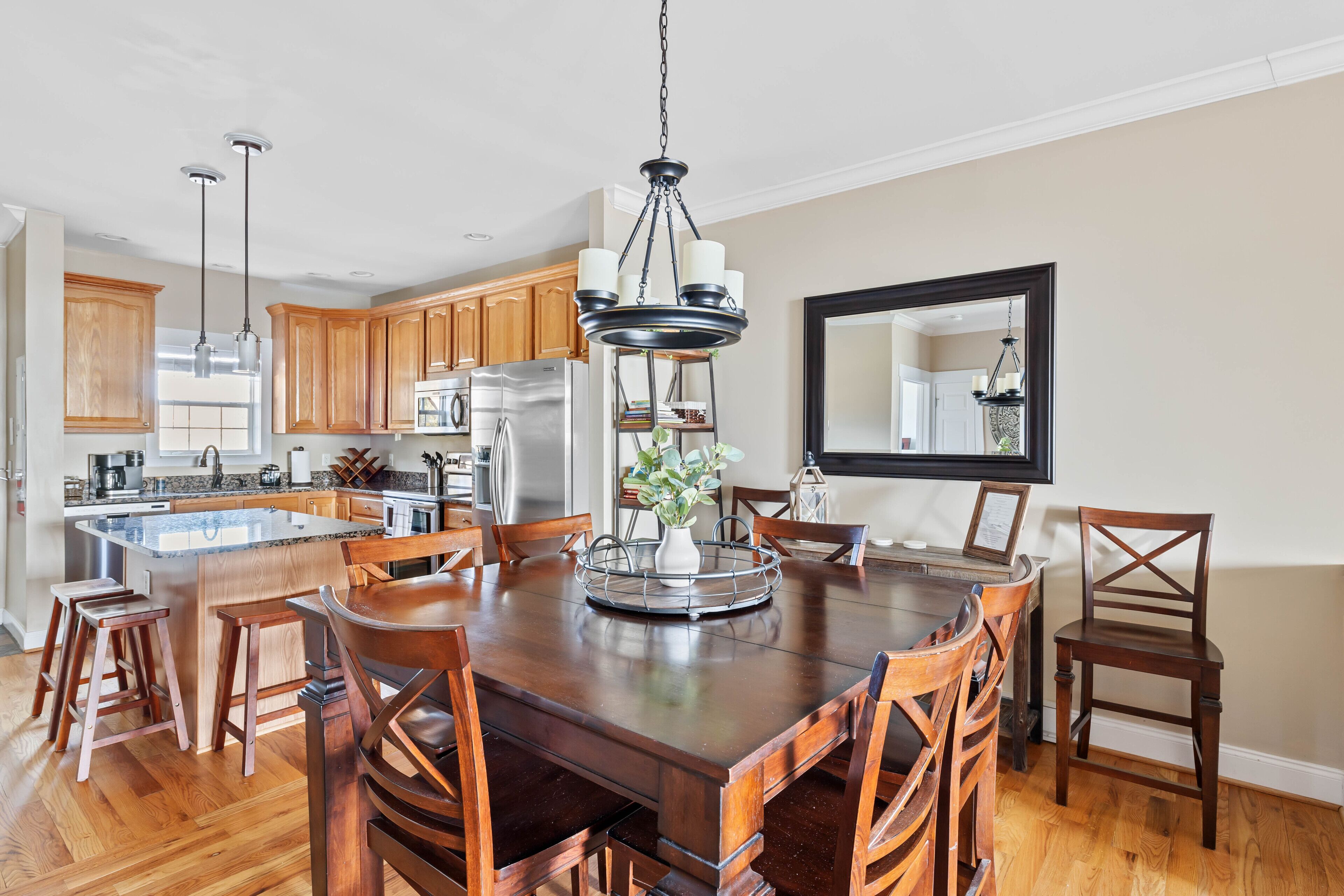 A spacious kitchen with wooden cabinets, a large island, and a dining area with a wooden table and chairs.