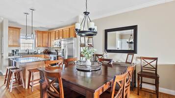 A spacious kitchen with wooden cabinets, a large island, and a dining area with a wooden table and chairs.