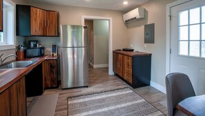 A modern kitchen with wooden cabinets, a stainless steel refrigerator, a microwave, and a built-in oven. - Luxury on the Edge of Traverse City (Williamsburg)