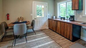 A compact kitchen with a wooden countertop, a built-in sink, and a window providing natural light. - Luxury on the Edge of Traverse City (Williamsburg)
