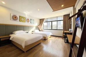 A hotel room with two beds, a desk, a TV, and artwork on the wall. - Migratory Haven · Xishan Hidden Inn (Wuyishan)