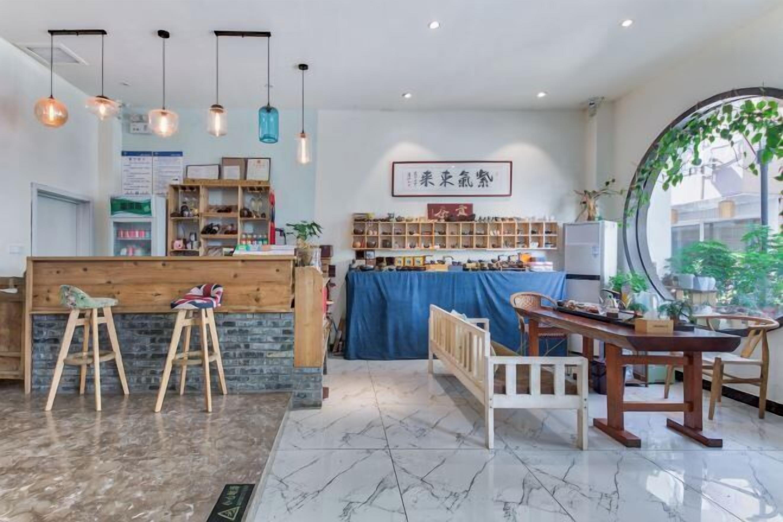 Un café chaleureux, avec des meubles en bois, un comptoir bleu et des étagères remplies de collations.