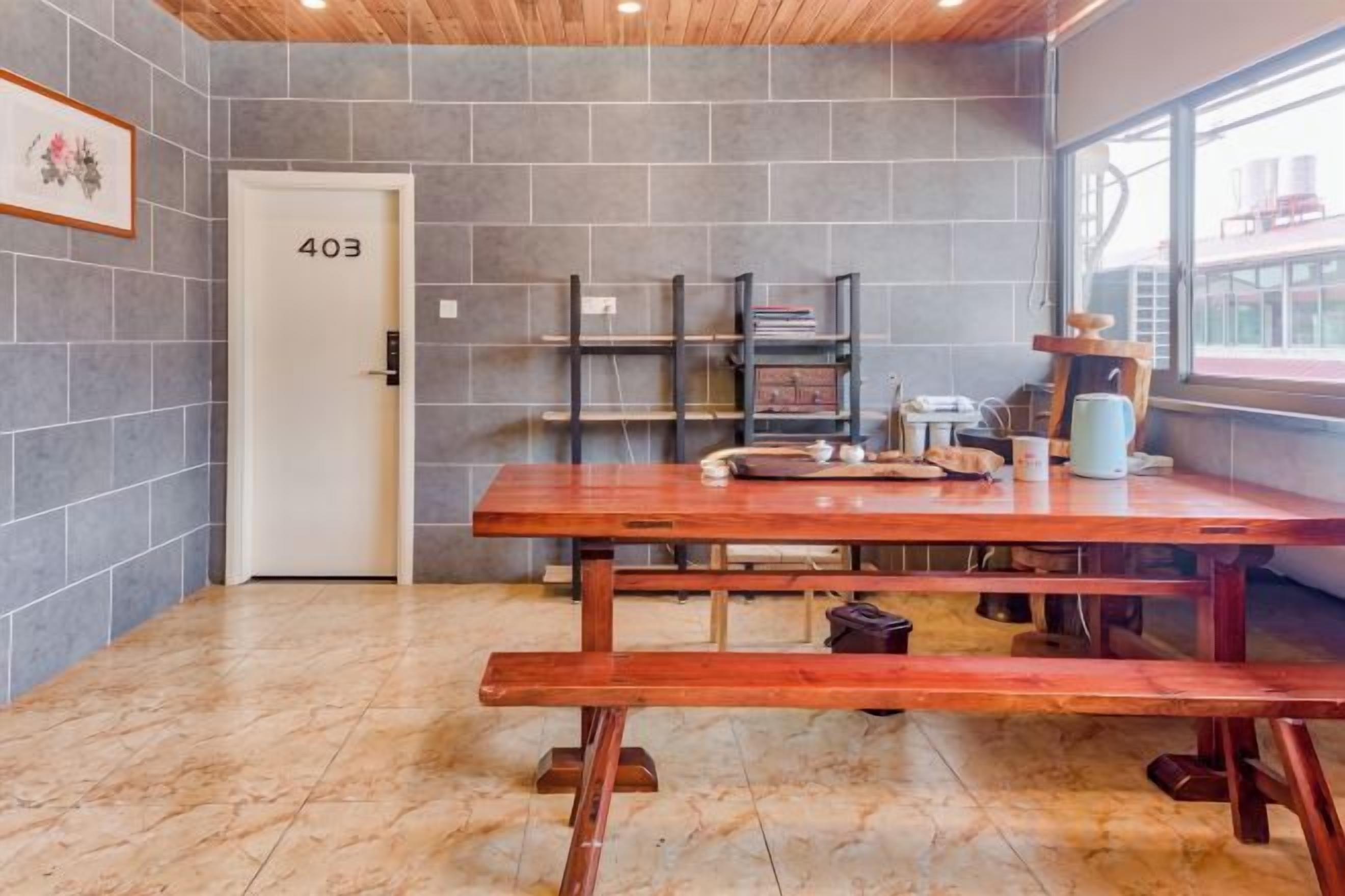 A room with a wooden table, shelves, and a door labeled '403'.