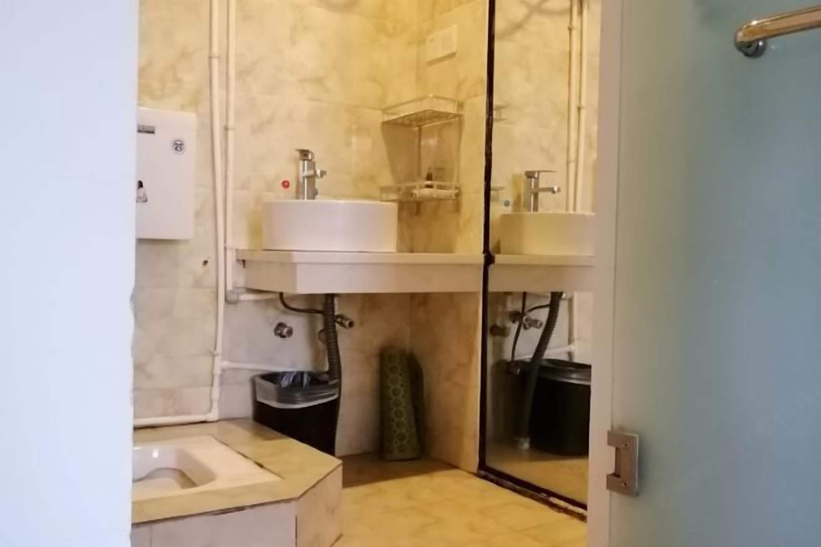 A compact bathroom with a toilet, sink, and shower area.