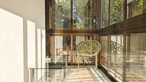 A modern interior with a glass table and chair, large windows, and a view of the outdoors. - LAS OLAS old town apartments (Benidorm)
